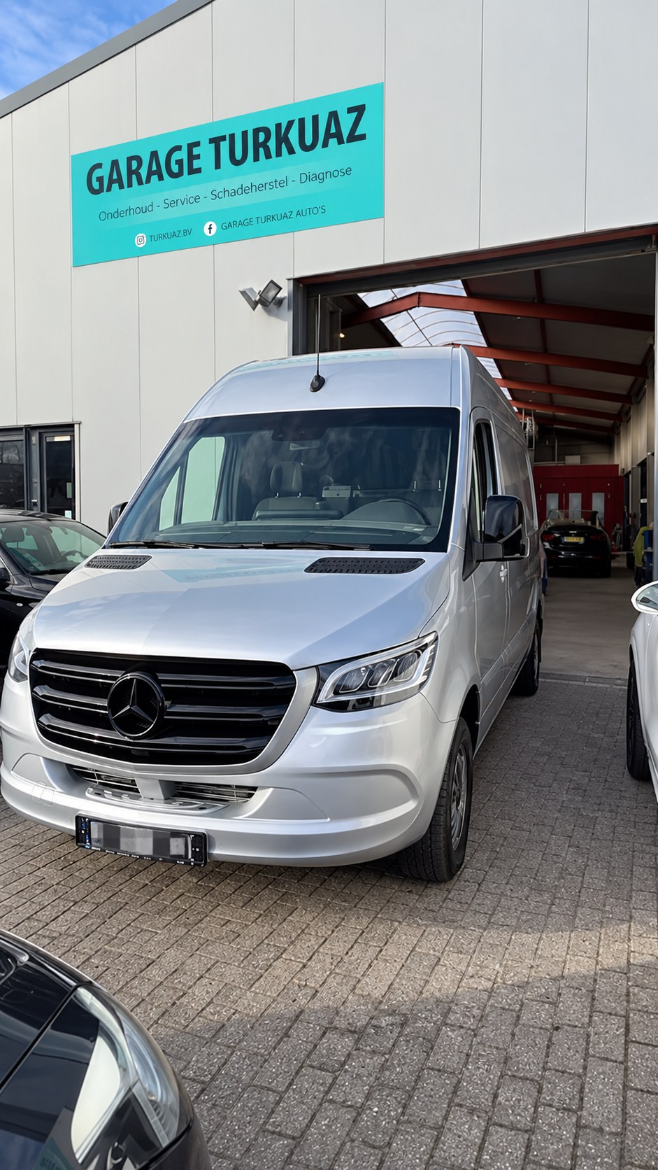 Zilveren Mercedes Sprinter bij de ingang van Garage Turkuaz
